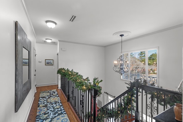 corridor featuring dark hardwood / wood-style flooring, an inviting chandelier, and ornamental molding