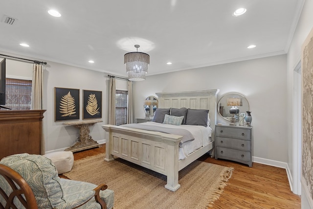 bedroom with light wood-type flooring, crown molding, and a chandelier