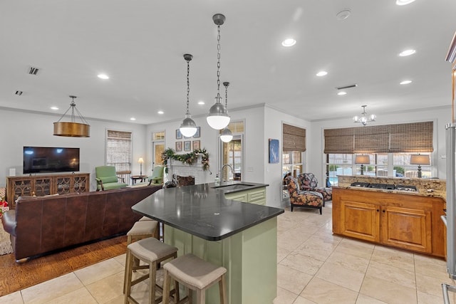 kitchen featuring light tile patterned floors, decorative light fixtures, a spacious island, and sink