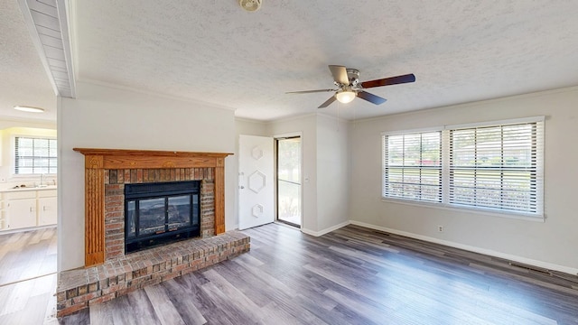 505 Massee Dr, Dothan, AL 36301 - unfurnished living room featuring a textured ceiling, a fireplace, ceiling fan, plenty of natural light, and wood finished floors