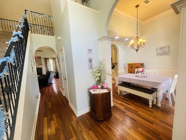 211 Paul Revere Run, Dothan, AL 36305 - dining room featuring arched walkways, crown molding, dark wood finished floors, a high ceiling, and a chandelier