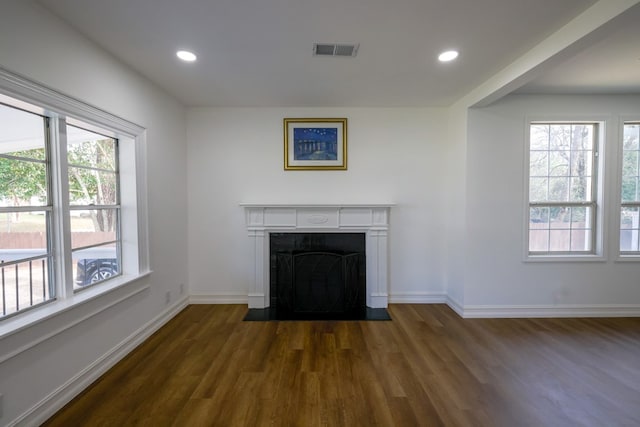 unfurnished living room with dark wood-type flooring and plenty of natural light