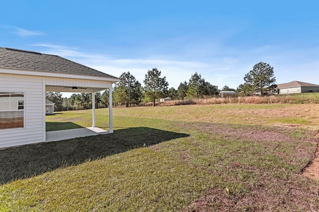 view of yard with ceiling fan and a patio area