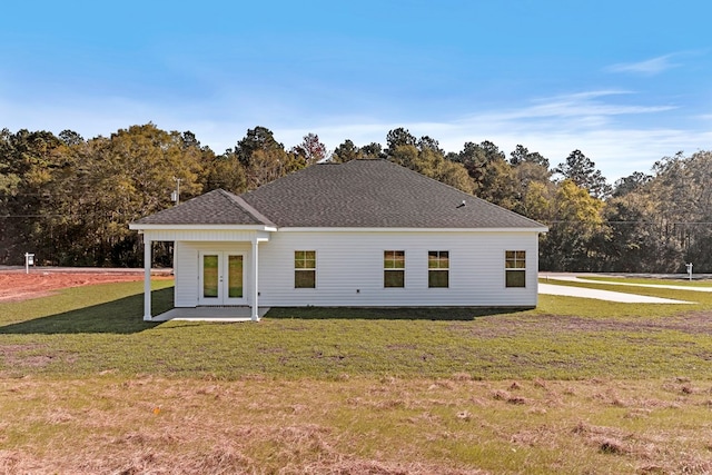 rear view of property featuring french doors and a lawn