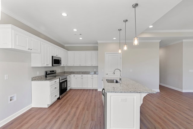 kitchen with stainless steel appliances, sink, light hardwood / wood-style flooring, white cabinets, and hanging light fixtures