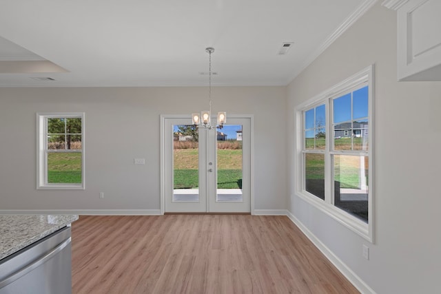 unfurnished dining area featuring a notable chandelier, ornamental molding, and light hardwood / wood-style flooring