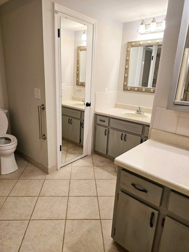 653 Honeysuckle Hills Rd, Ozark, AL 36360 - full bath featuring toilet, tile patterned flooring, two vanities, and tasteful backsplash