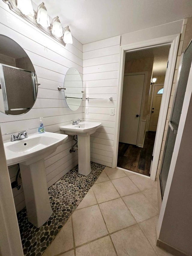 653 Honeysuckle Hills Rd, Ozark, AL 36360 - bathroom featuring a shower stall, tile patterned floors, and wood walls