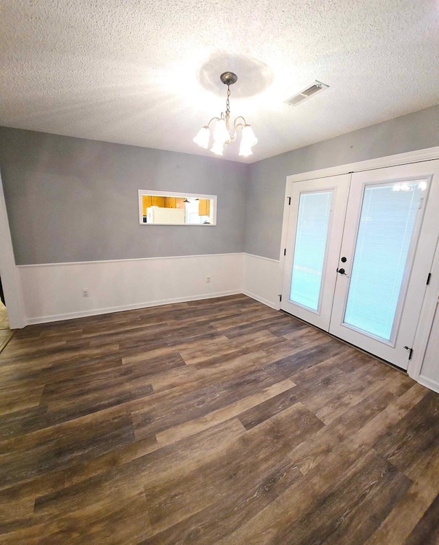 653 Honeysuckle Hills Rd, Ozark, AL 36360 - unfurnished room featuring dark wood-type flooring, french doors, a chandelier, and a textured ceiling