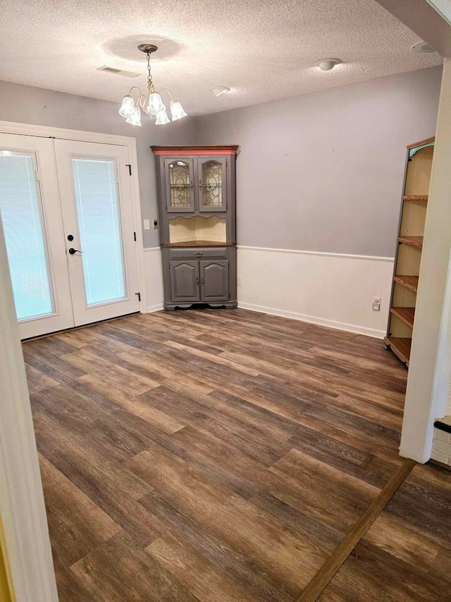 653 Honeysuckle Hills Rd, Ozark, AL 36360 - unfurnished dining area with dark wood-type flooring, a chandelier, a textured ceiling, french doors, and wainscoting