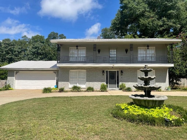 view of front facade with a garage, a balcony, and a front yard