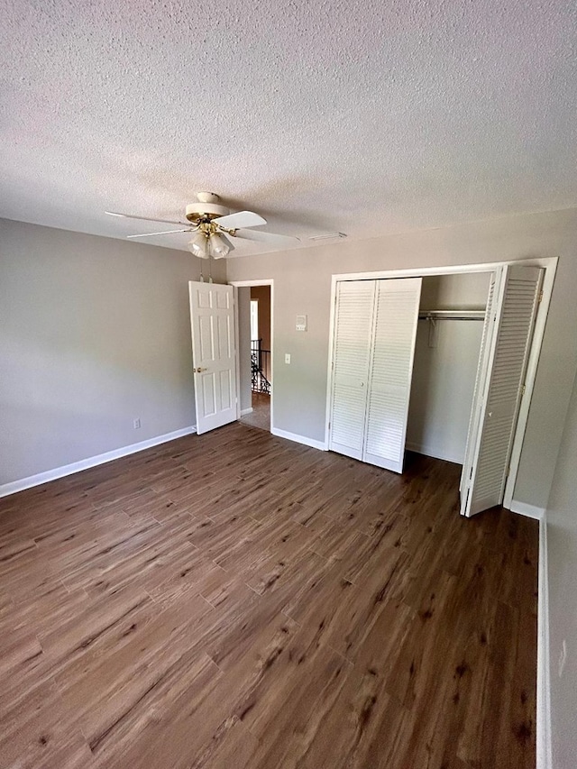 unfurnished bedroom with ceiling fan, a closet, dark hardwood / wood-style flooring, and a textured ceiling