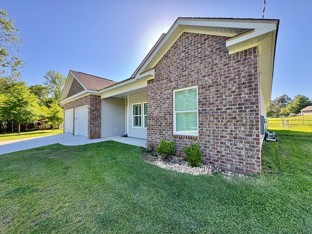 view of home's exterior featuring an attached garage, brick siding, fence, and a yard