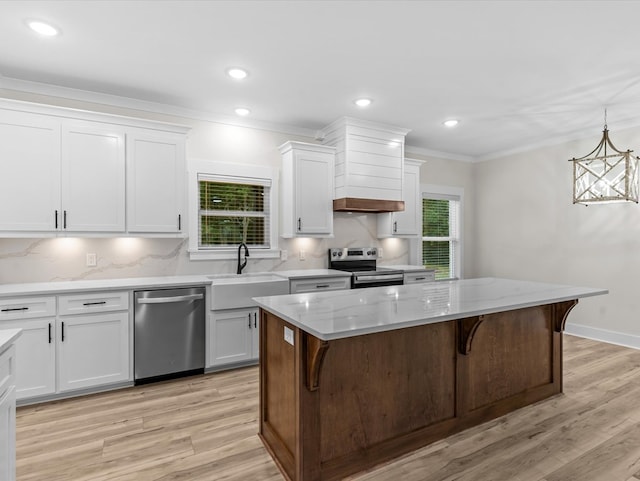 146 County Road 657, Chancellor, AL 36316 - kitchen featuring stainless steel appliances, a center island, white cabinetry, light wood-style flooring, and ornamental molding