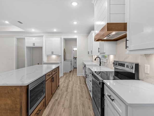 146 County Road 657, Chancellor, AL 36316 - kitchen featuring stainless steel appliances, premium range hood, light wood-type flooring, white cabinetry, and recessed lighting