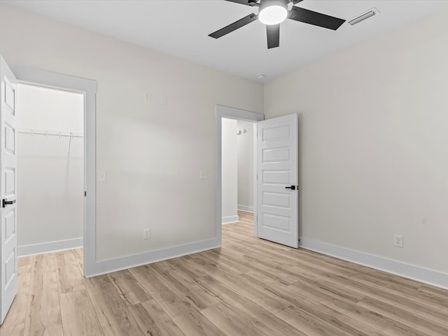 146 County Road 657, Chancellor, AL 36316 - unfurnished bedroom with light wood-type flooring, a walk in closet, a closet, and ceiling fan