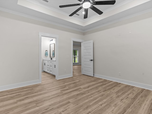 146 County Road 657, Chancellor, AL 36316 - unfurnished bedroom with crown molding, a tray ceiling, light wood-style floors, ensuite bathroom, and ceiling fan