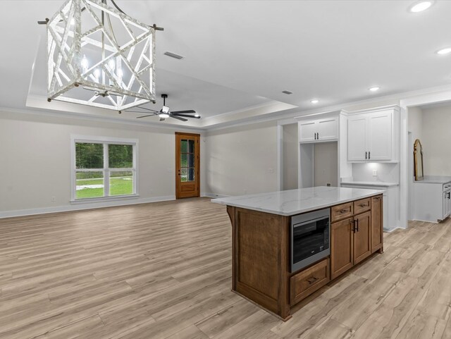 146 County Road 657, Chancellor, AL 36316 - kitchen featuring stainless steel microwave, a tray ceiling, white cabinetry, light wood-type flooring, and recessed lighting