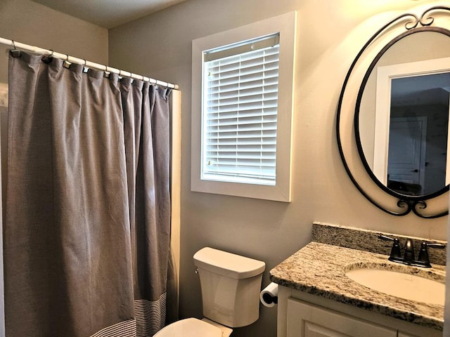 full bathroom with vanity, curtained shower, and toilet