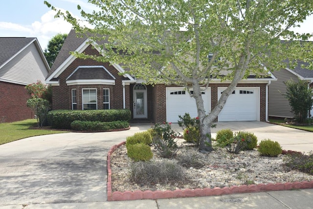 view of front of home with an attached garage, driveway, and brick siding