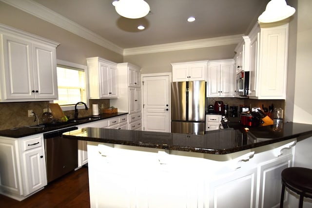 kitchen with a peninsula, appliances with stainless steel finishes, and white cabinets