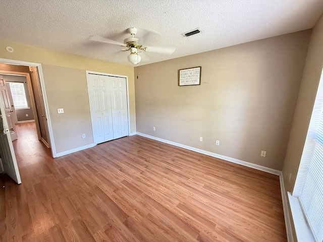 291 Nomad Cir, Kinsey, AL 36303 - unfurnished bedroom featuring light wood-style floors, a textured ceiling, a closet, and ceiling fan