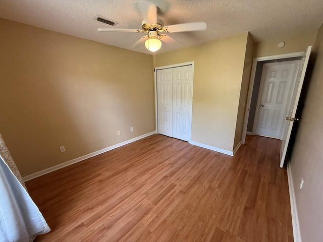 291 Nomad Cir, Kinsey, AL 36303 - unfurnished bedroom featuring light wood-style floors, a textured ceiling, a closet, and a ceiling fan