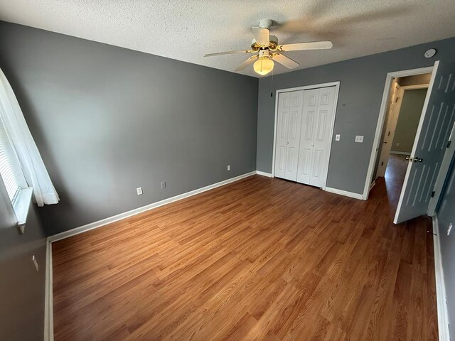 291 Nomad Cir, Kinsey, AL 36303 - unfurnished bedroom featuring wood finished floors, a textured ceiling, a closet, and a ceiling fan