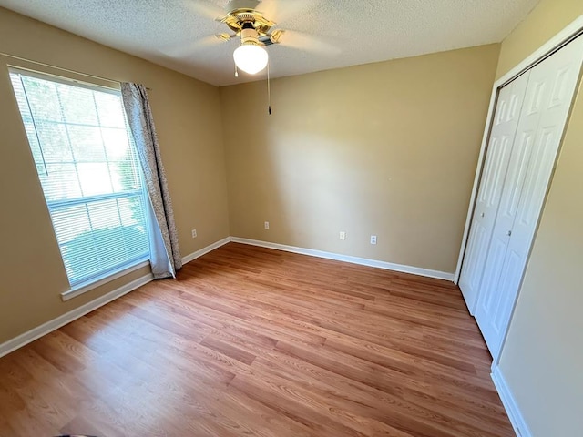 291 Nomad Cir, Kinsey, AL 36303 - unfurnished bedroom with light wood-type flooring, a textured ceiling, a closet, and a ceiling fan