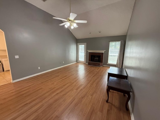 291 Nomad Cir, Kinsey, AL 36303 - unfurnished living room with ceiling fan, high vaulted ceiling, light wood-type flooring, and a fireplace