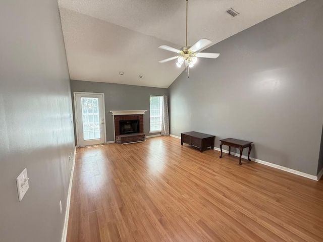 291 Nomad Cir, Kinsey, AL 36303 - unfurnished living room featuring a ceiling fan, light wood-style flooring, a fireplace, and high vaulted ceiling