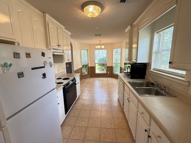 291 Nomad Cir, Kinsey, AL 36303 - kitchen featuring white appliances, under cabinet range hood, a chandelier, a textured ceiling, and white cabinetry