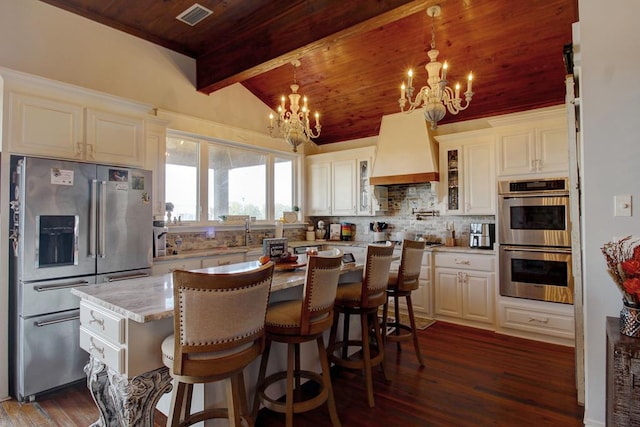 kitchen with lofted ceiling with beams, wooden ceiling, hanging light fixtures, and appliances with stainless steel finishes