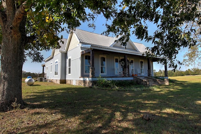 farmhouse featuring covered porch, central AC, and a front yard