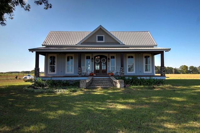 farmhouse inspired home featuring covered porch, french doors, and a front lawn