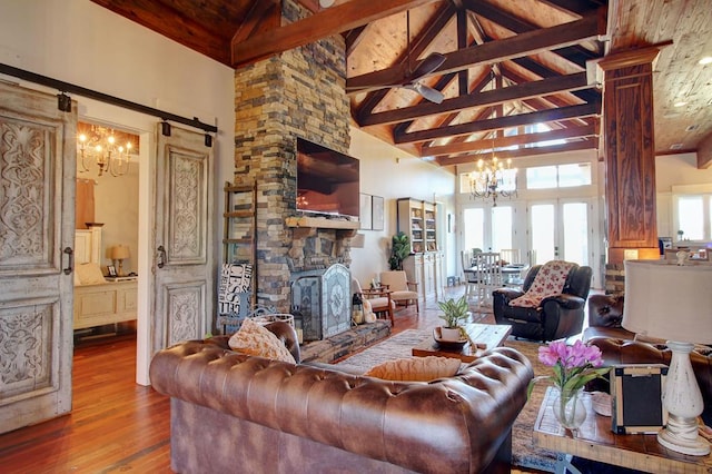 living room featuring french doors, high vaulted ceiling, beamed ceiling, hardwood / wood-style floors, and a fireplace