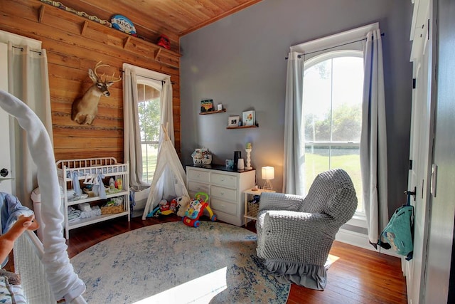 bedroom featuring hardwood / wood-style flooring, wood walls, and wooden ceiling