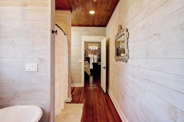 hallway featuring dark hardwood / wood-style flooring, wooden ceiling, and wood walls