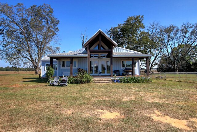 back of property with french doors and a yard