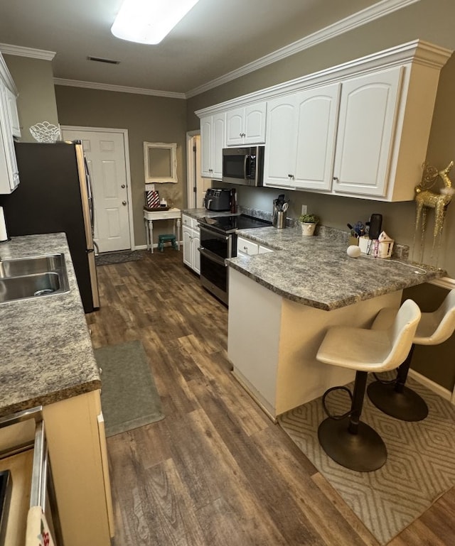 kitchen with white cabinetry, sink, ornamental molding, and appliances with stainless steel finishes