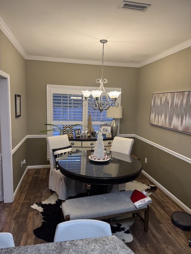 dining area with crown molding, dark wood-type flooring, and a notable chandelier