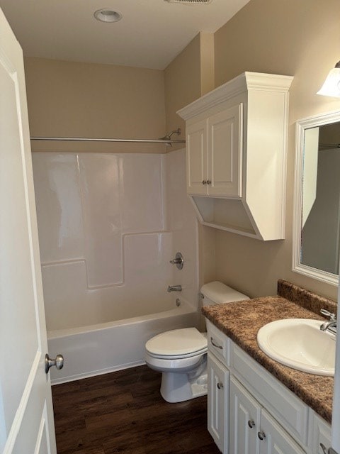 full bathroom featuring shower / tub combination, vanity, wood-type flooring, and toilet