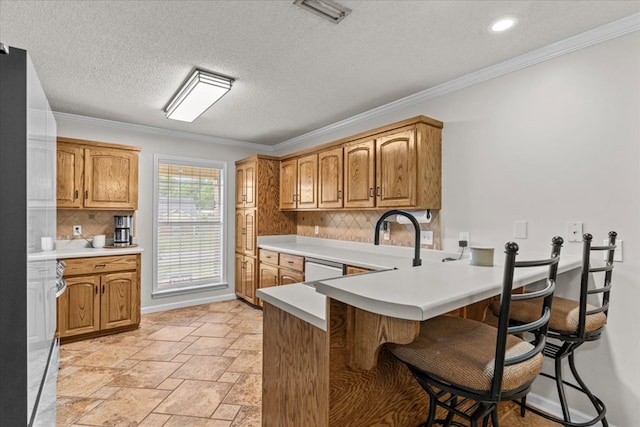 24 County Road 278, Enterprise, AL 36330 - kitchen featuring a kitchen bar, backsplash, crown molding, a peninsula, and light countertops