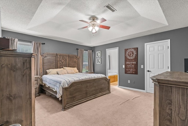 24 County Road 278, Enterprise, AL 36330 - bedroom featuring a tray ceiling, multiple windows, light colored carpet, a textured ceiling, and connected bathroom