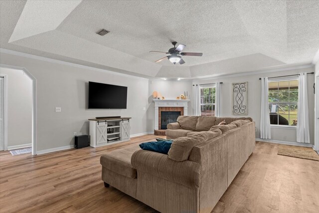 24 County Road 278, Enterprise, AL 36330 - living area featuring a raised ceiling, light wood-style flooring, ceiling fan, ornamental molding, and a textured ceiling
