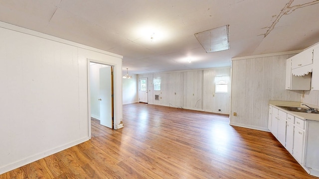 interior space with a sink, baseboards, a healthy amount of sunlight, and light wood-style floors