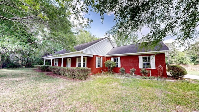 view of front facade featuring covered porch, brick siding, and a front lawn