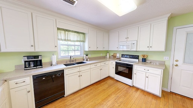 kitchen featuring white microwave, range with electric cooktop, black dishwasher, a sink, and visible vents