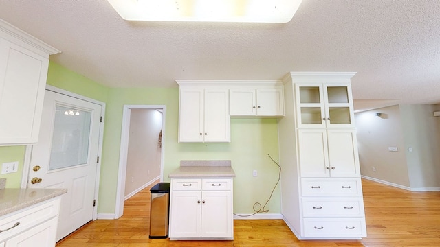 kitchen with light wood finished floors and white cabinets