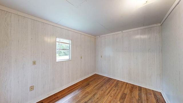 spare room with wood finished floors and baseboards